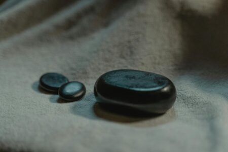 Professional gua sha tools and jade stones arranged on clean surface for makeup application