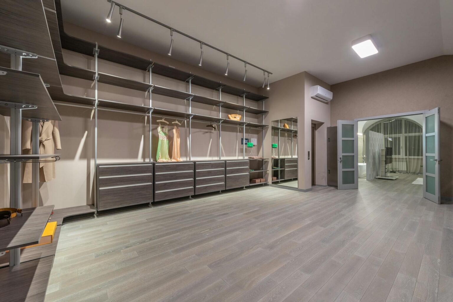 Organized luxury walk-in closet with designer clothing and accessories neatly arranged