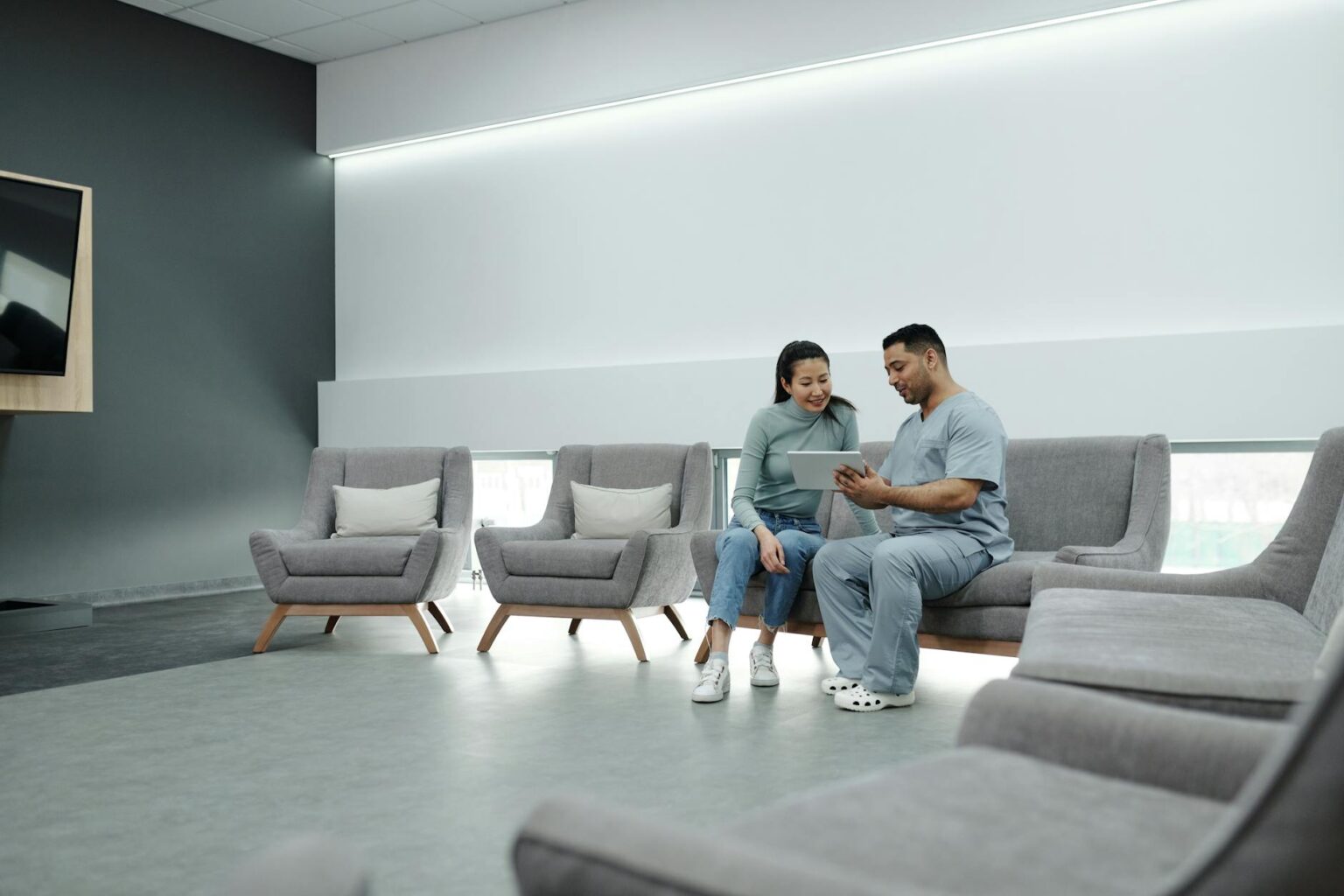 Modern hospital waiting room with chairs and medical equipment visible