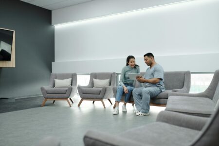 Modern hospital waiting room with chairs and medical equipment visible