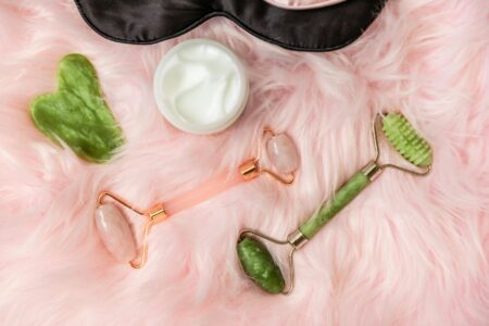 Various skincare tools and devices arranged on white background