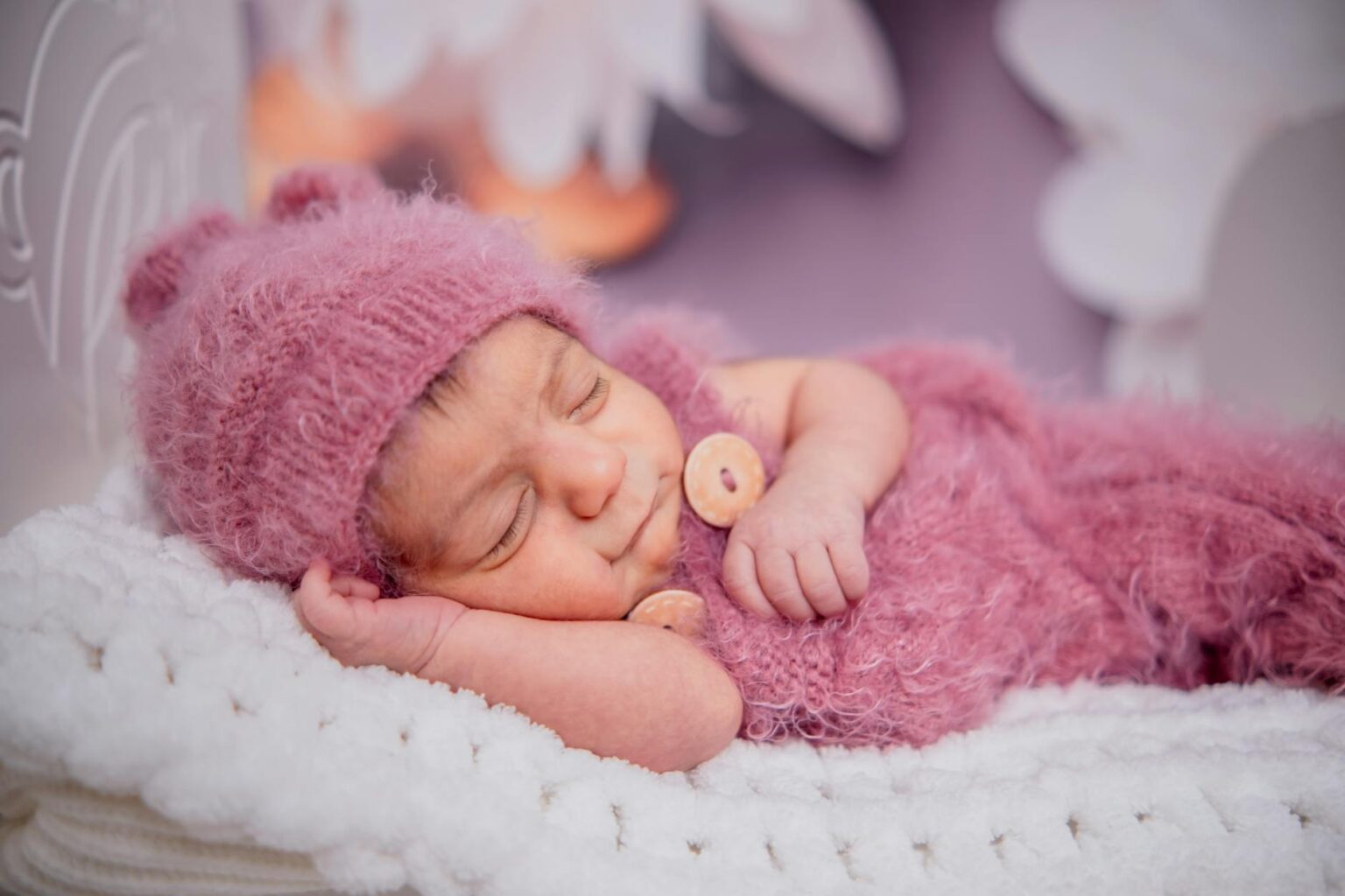 Peaceful sleeping infant in white bedding demonstrating successful sleep training results