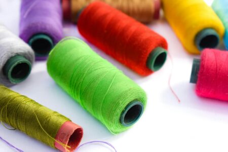 Colorful embroidery threads arranged in organized display showing various textures and metallic accents