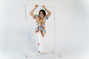 Vintage clothing hanging on metal rack showing assorted band t-shirts and retro fashion pieces
