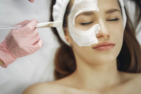 Esthetician performing gentle facial massage treatment on client in spa setting