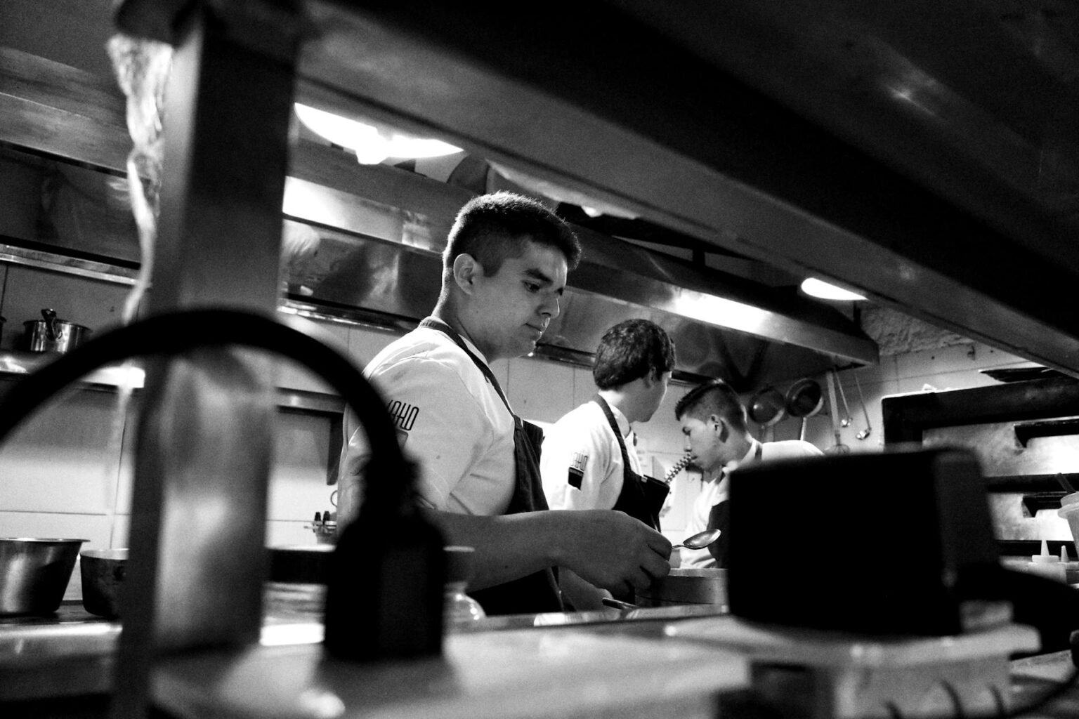 Professional restaurant kitchen with stainless steel equipment and tiled floors