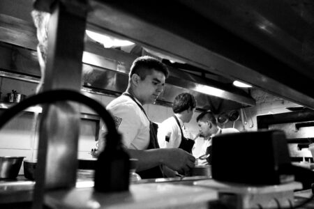 Professional restaurant kitchen with stainless steel equipment and tiled floors