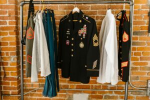 Olive green military style jacket hanging on clothing rack