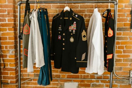 Olive green military style jacket hanging on clothing rack