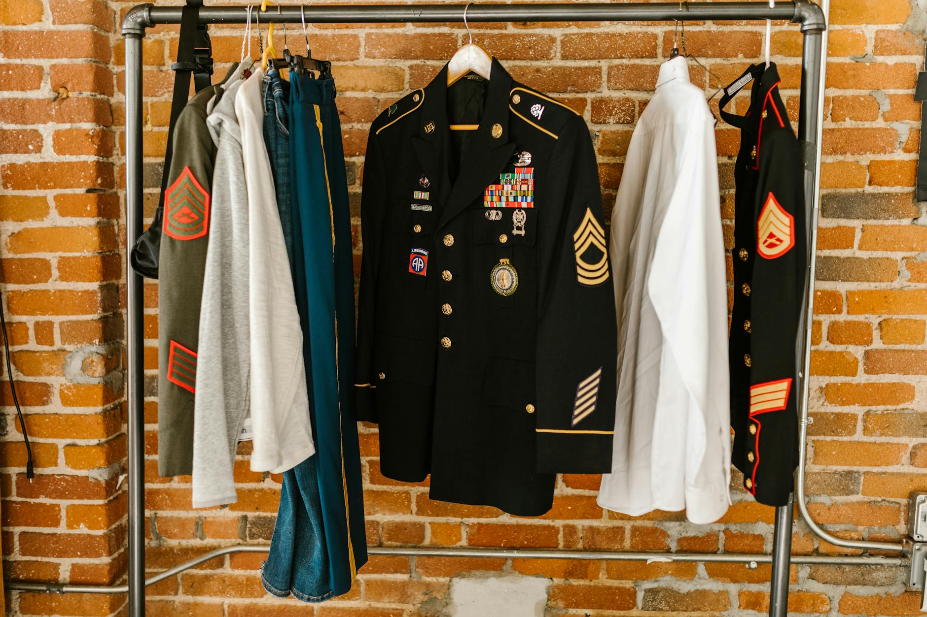 Olive green military style jacket hanging on clothing rack