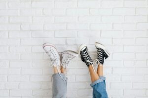 Clean white sneakers on concrete surface showcasing minimalist athletic footwear design