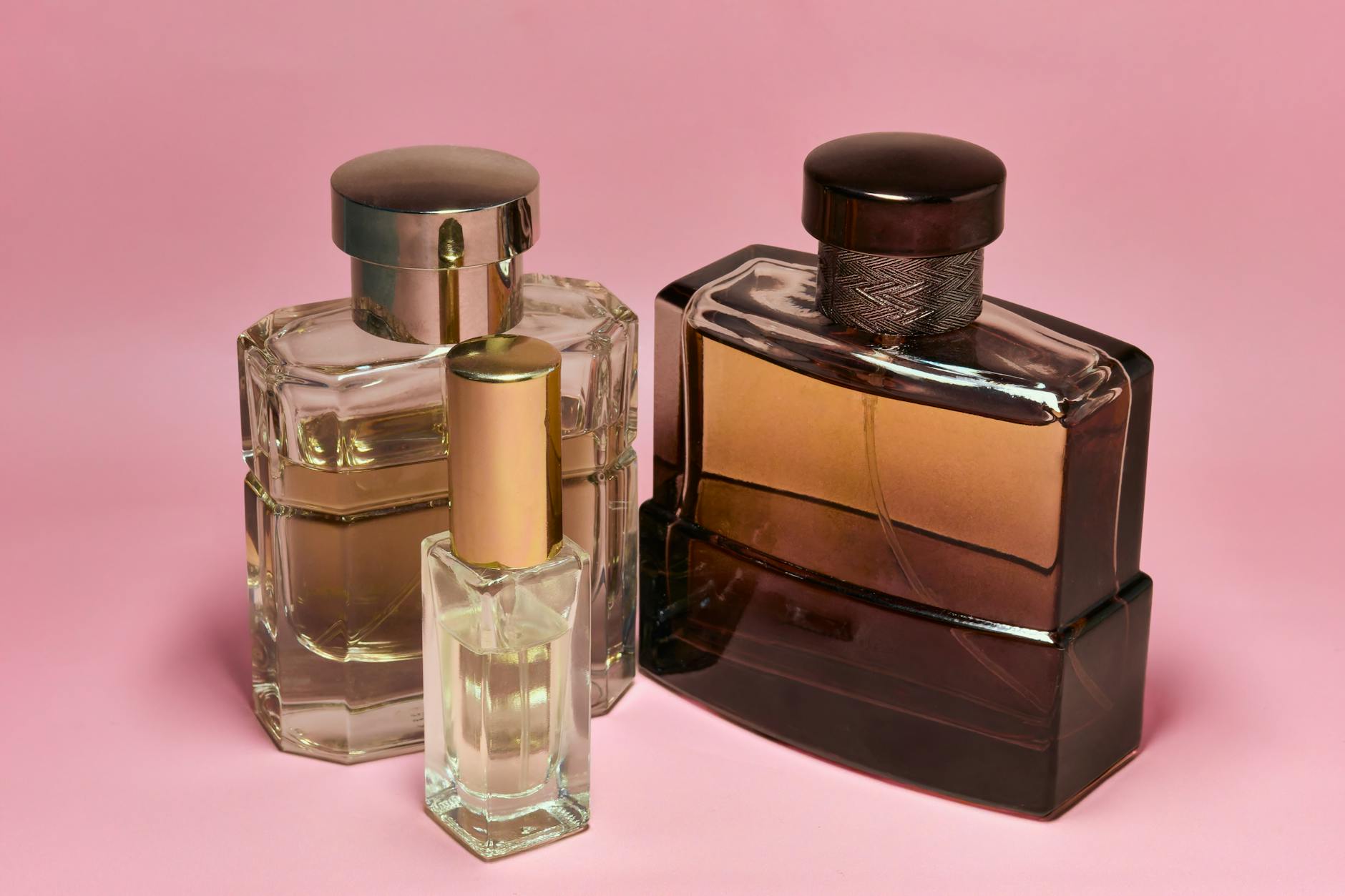Elegant glass perfume bottles arranged on white surface showing luxury fragrance presentation