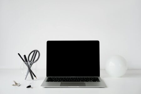 Person organizing digital files on laptop computer with clean workspace