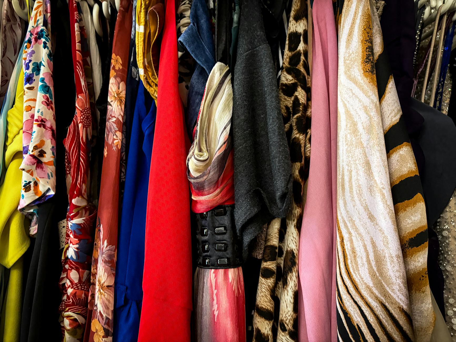 Collection of vintage band t-shirts hanging on clothing rack in boutique store
