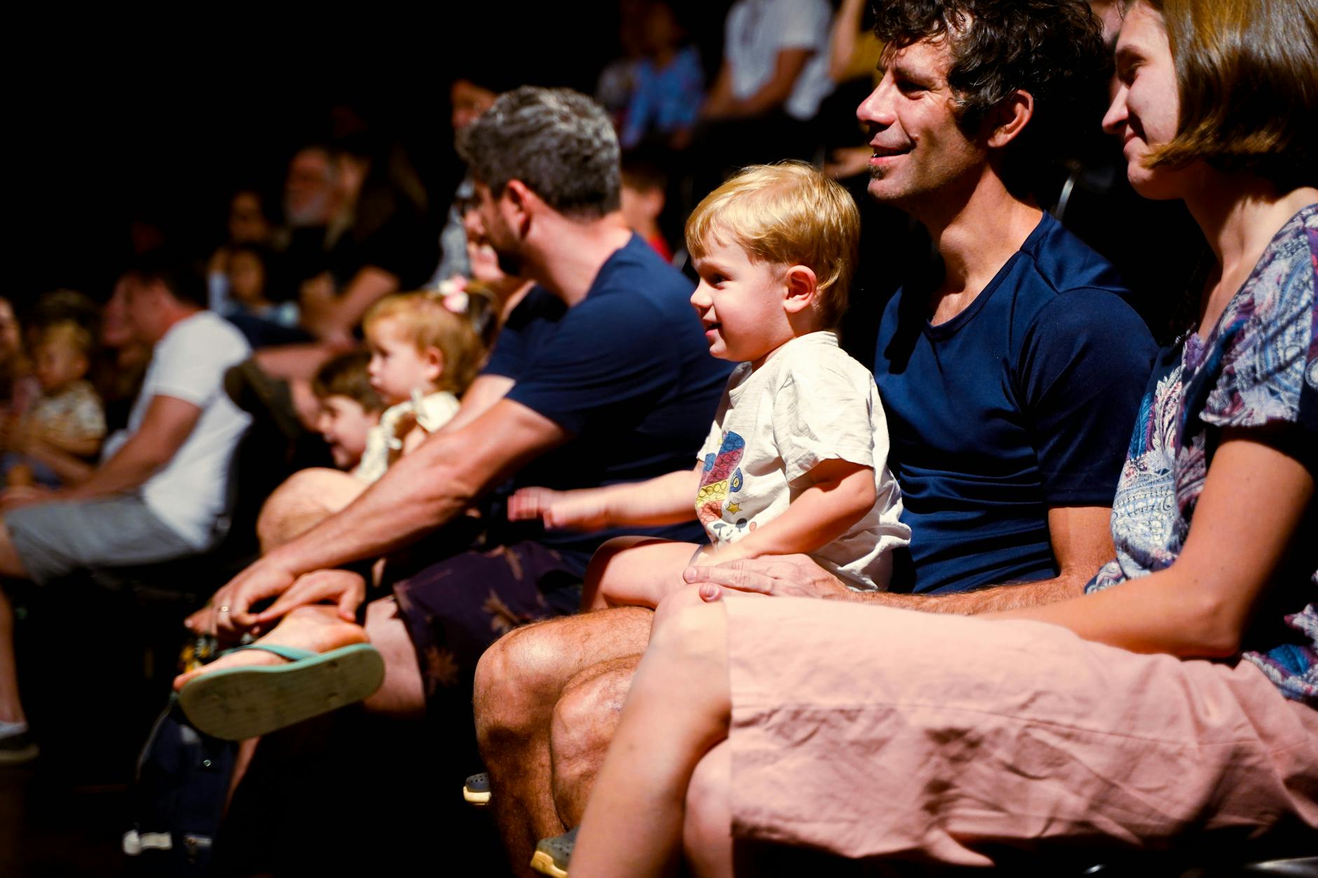 Diverse audience watching fashion presentation with engaged expressions