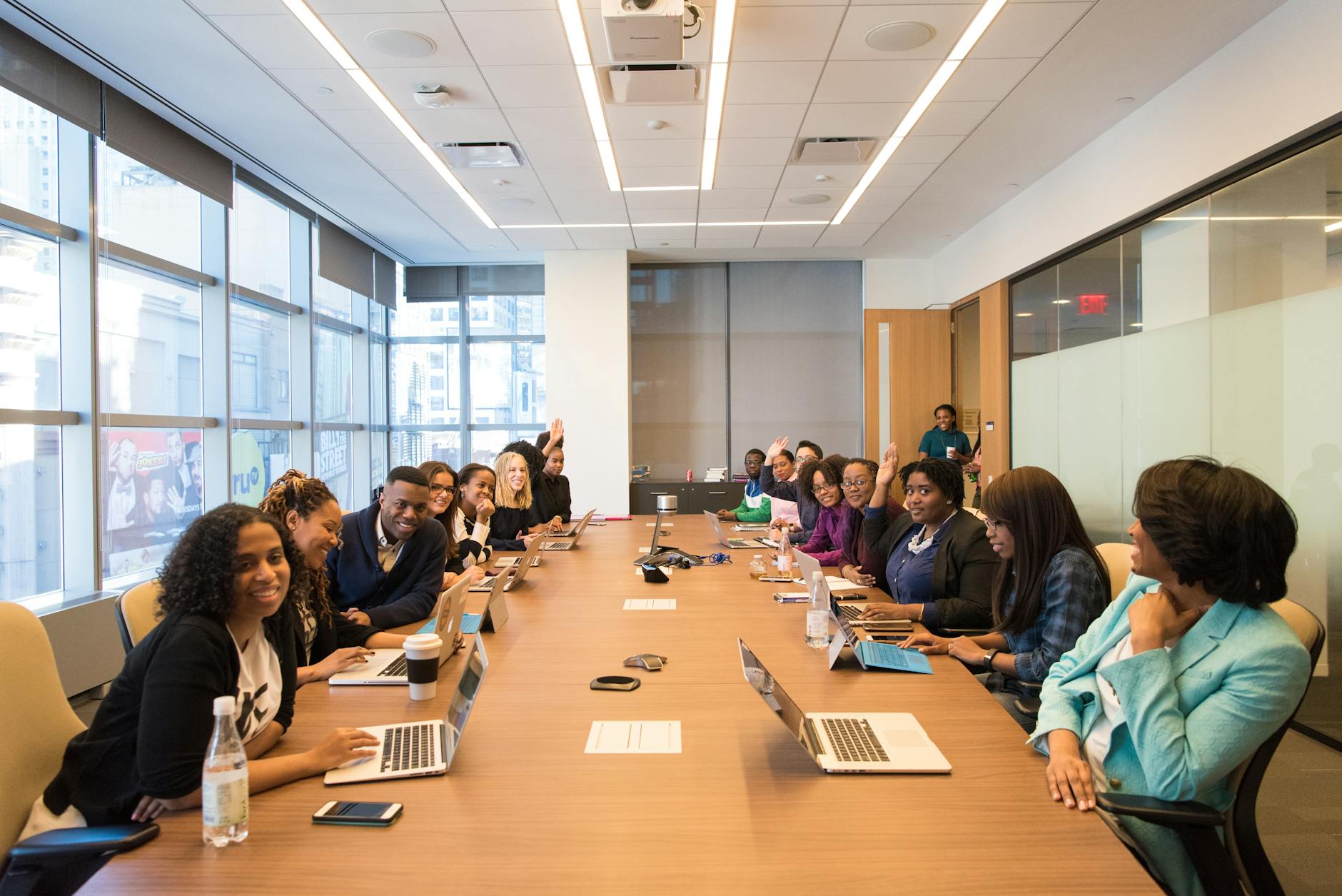 Business professionals in meeting room discussing strategies around conference table