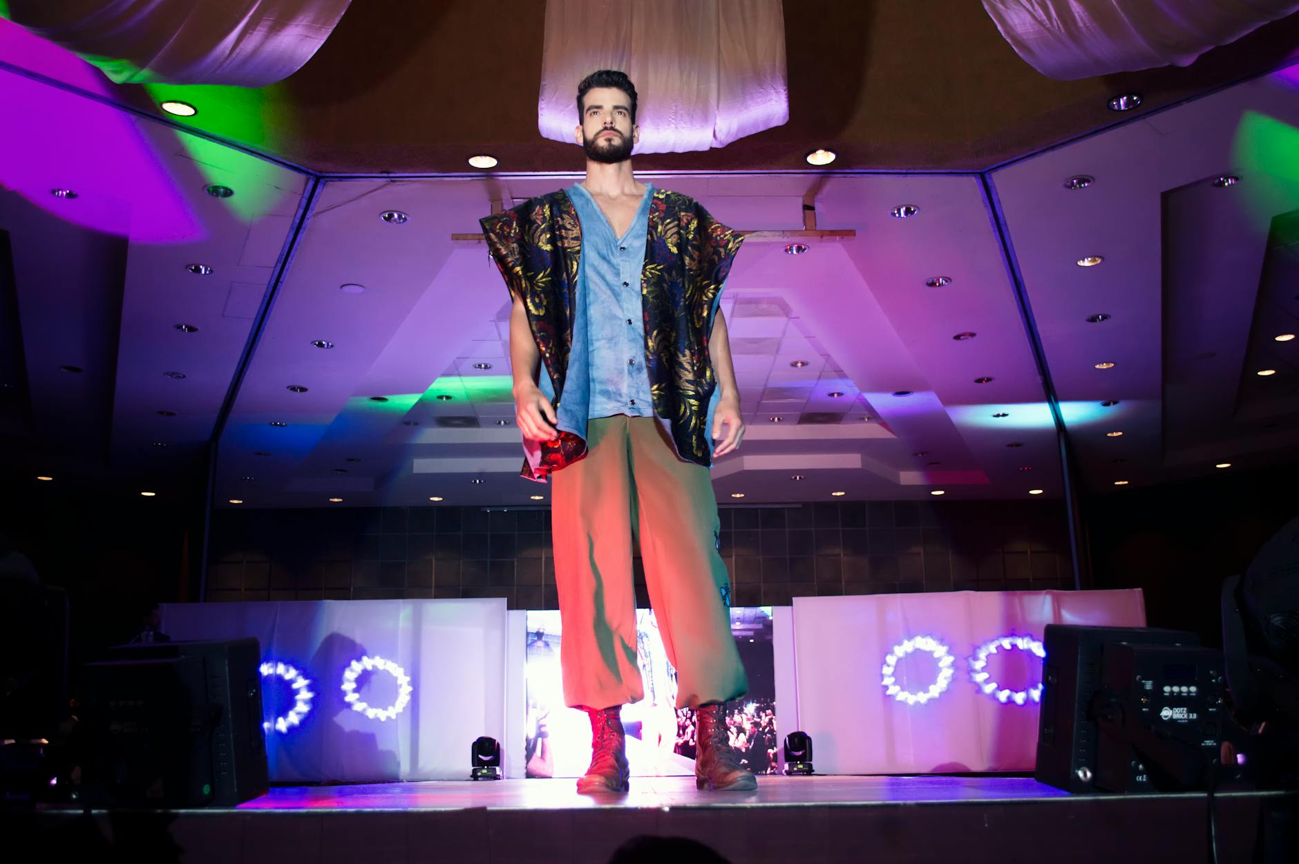 Models walking on runway during fashion show with seated audience