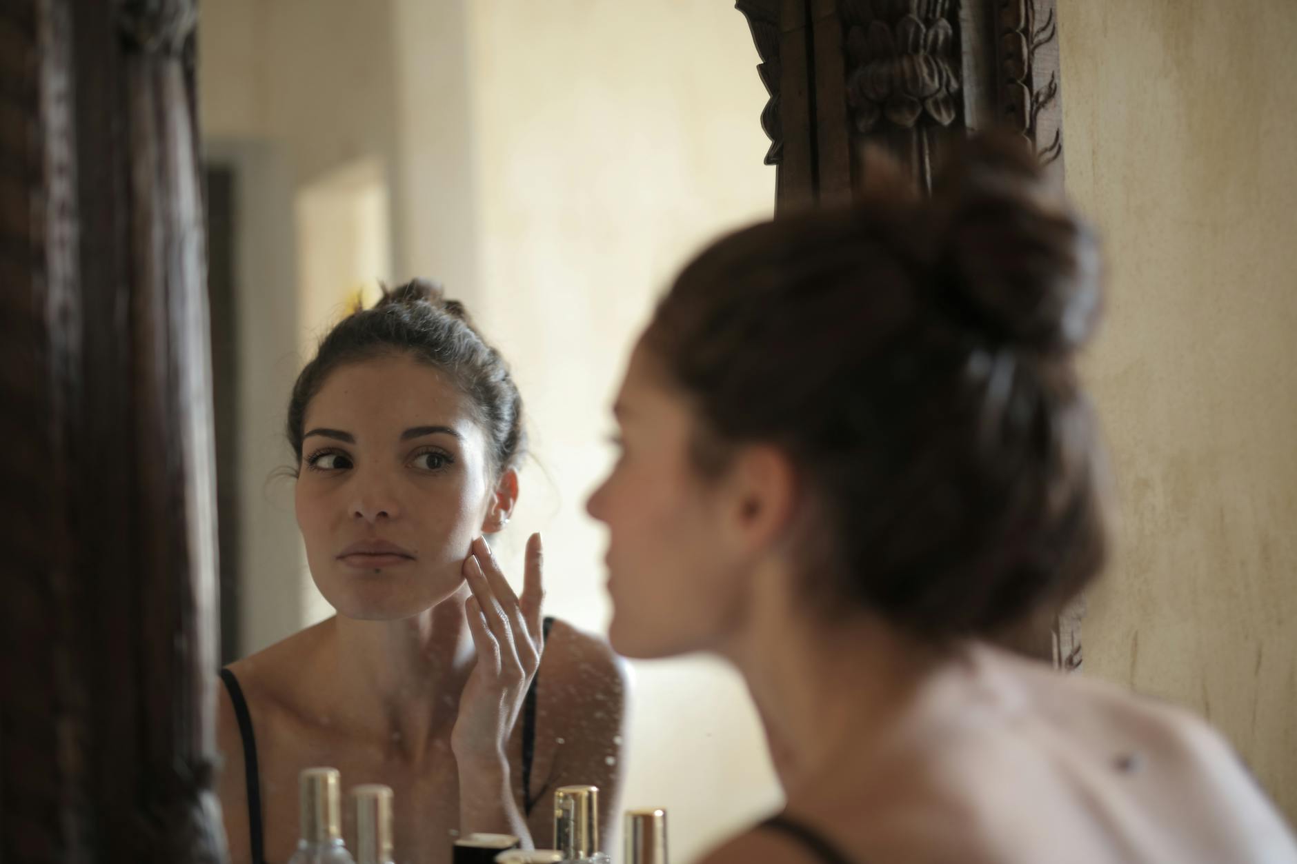 Woman using facial skincare device in home bathroom setting
