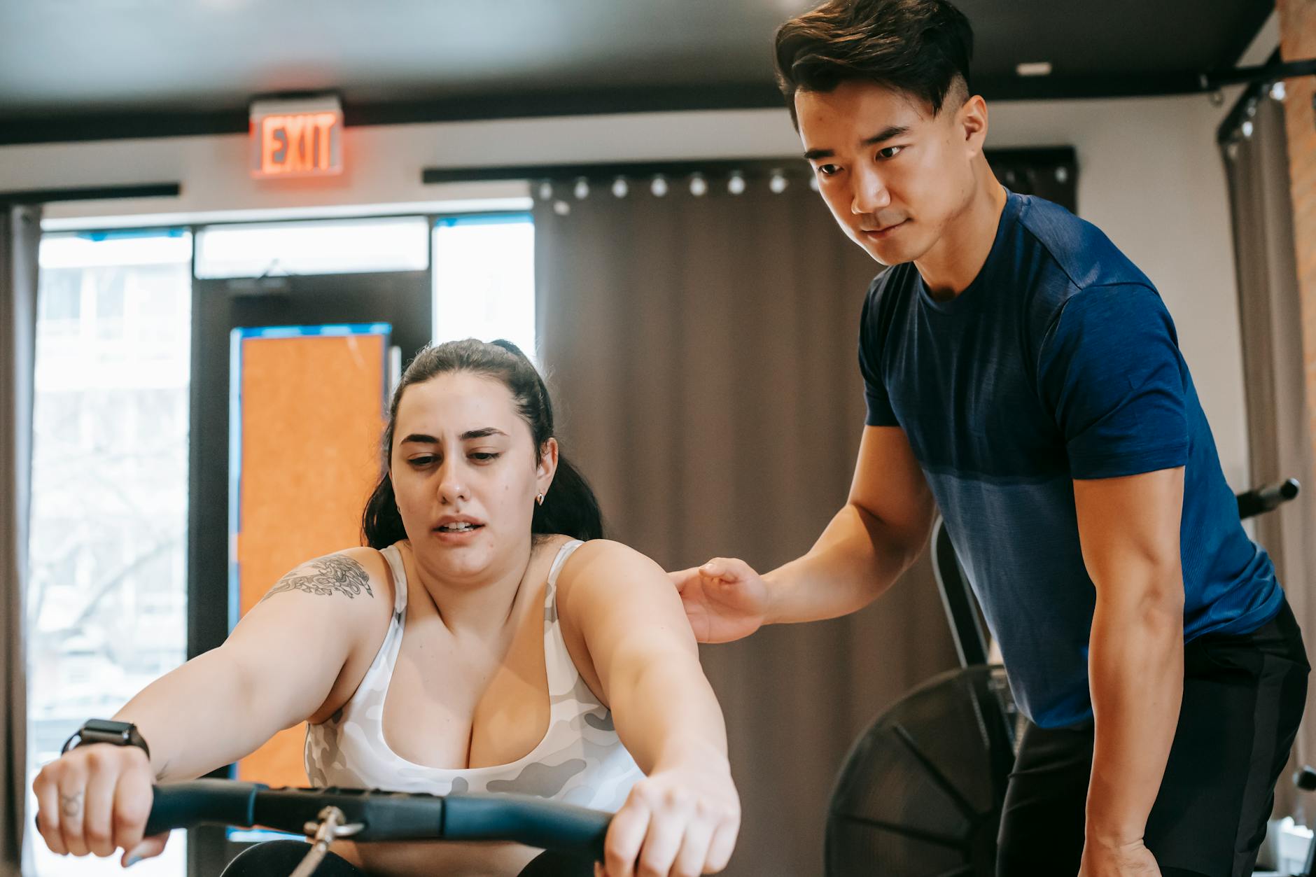Professional fitness trainer demonstrating exercise techniques in upscale gym environment