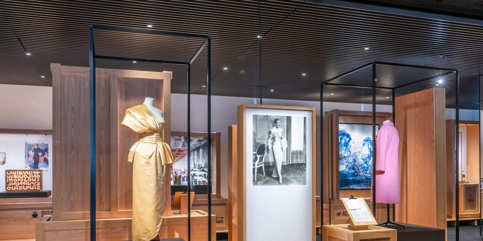 Elegant Parisian luxury boutique interior with glass display cases and heritage accessories
