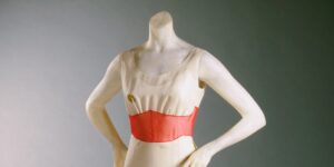 A New Exhibition Proves That Fashion Was Always on Dalí’s Mind Modern art gallery with spotlit artworks displayed on white walls