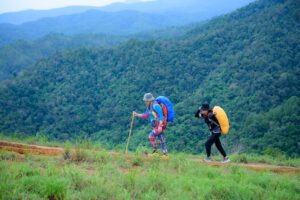 Women hiking outdoors wearing trail footwear on a forest path