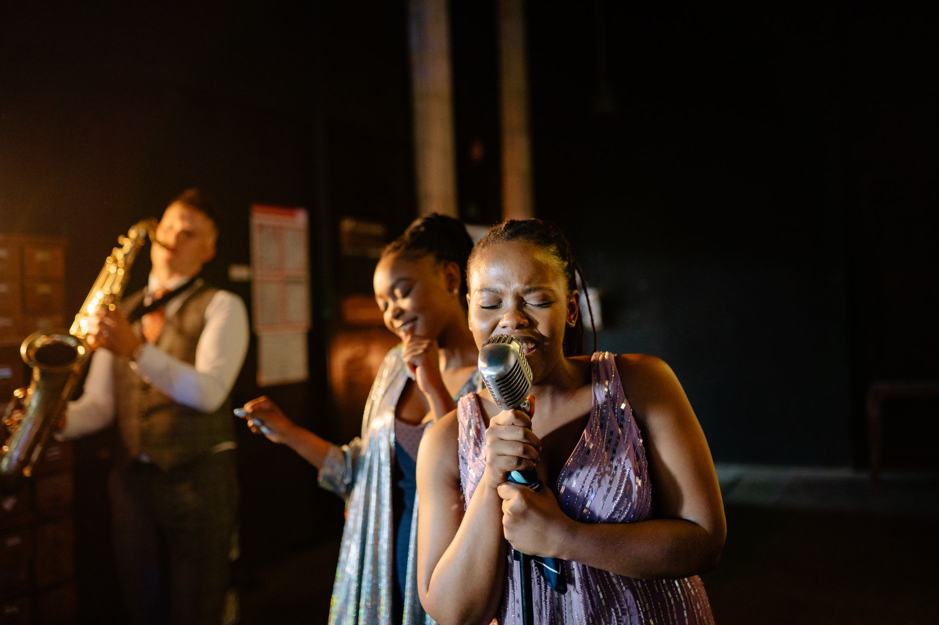 Young women in performance attire backstage preparing for a show
