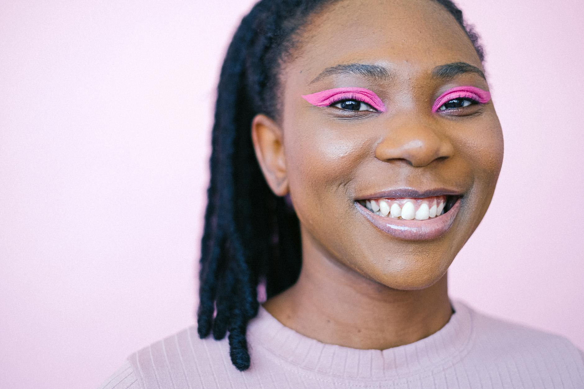 Model wearing bold graphic black eyeliner and colorful eye shadow in an editorial makeup look
