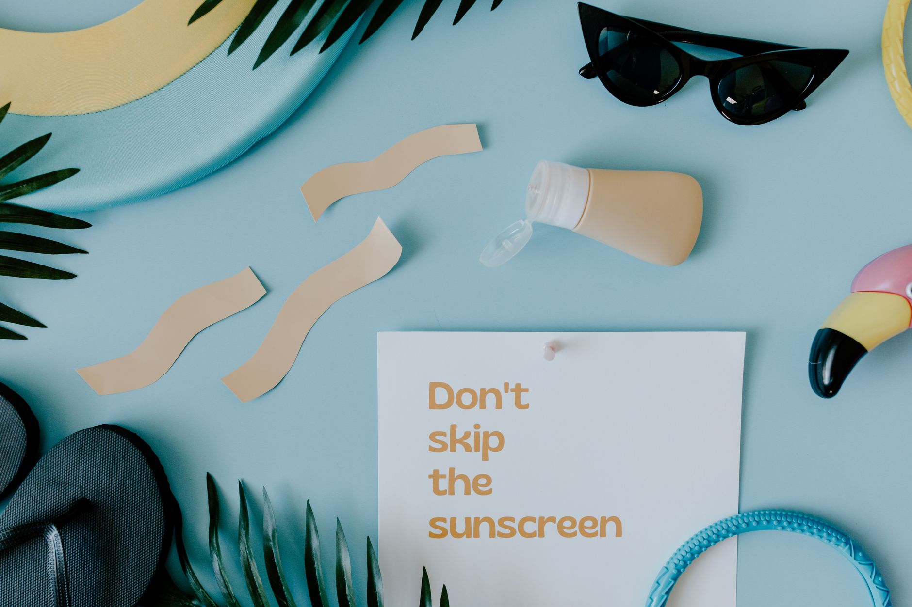 Sunscreen and skin care products arranged in a flat lay on a white background