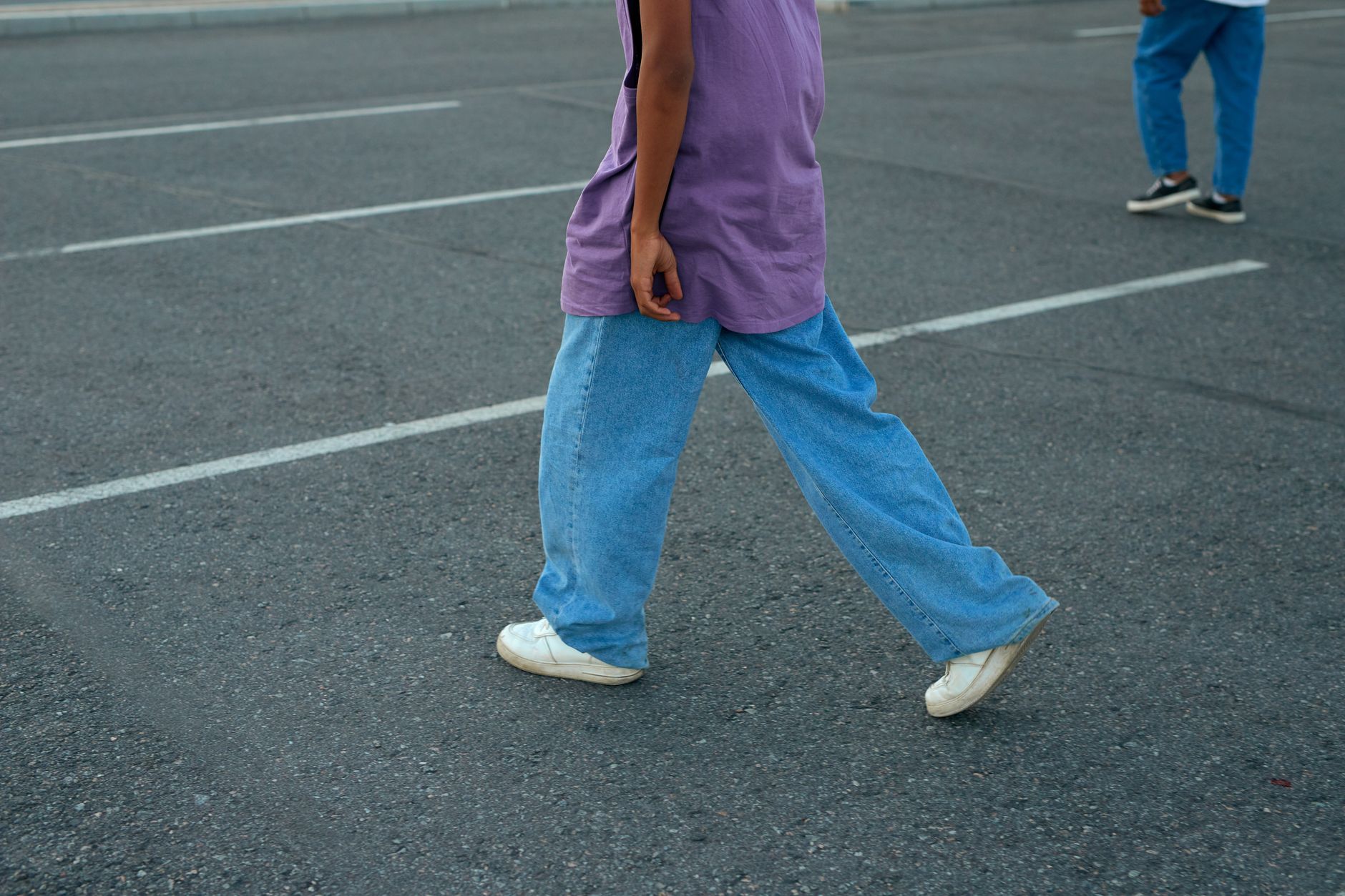 Person wearing lifestyle sneakers on an urban street pavement