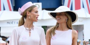 Elegantly dressed guests at a horse racing event in coordinated pastel outfits
