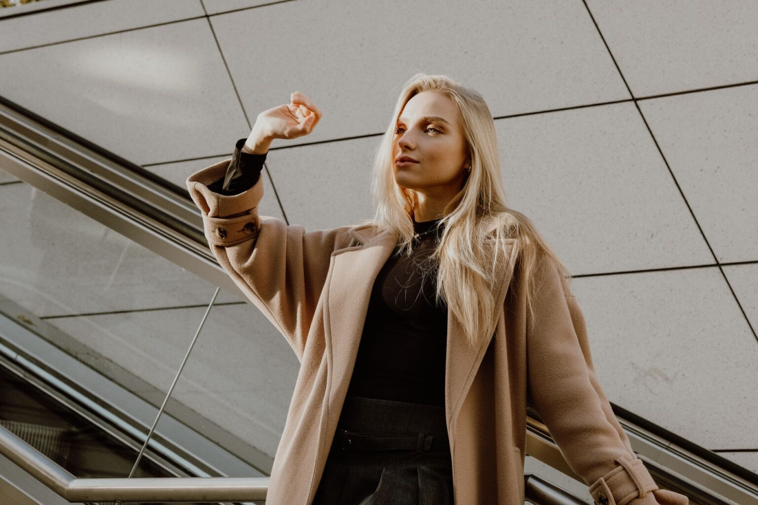 A woman wearing a tailored camel wool coat, representing Max Mara's signature outerwear aesthetic
