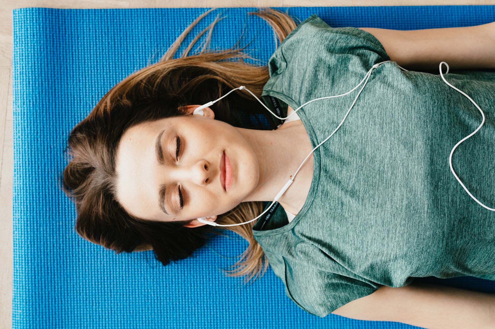 Person listening to audio with headphones while resting in low light