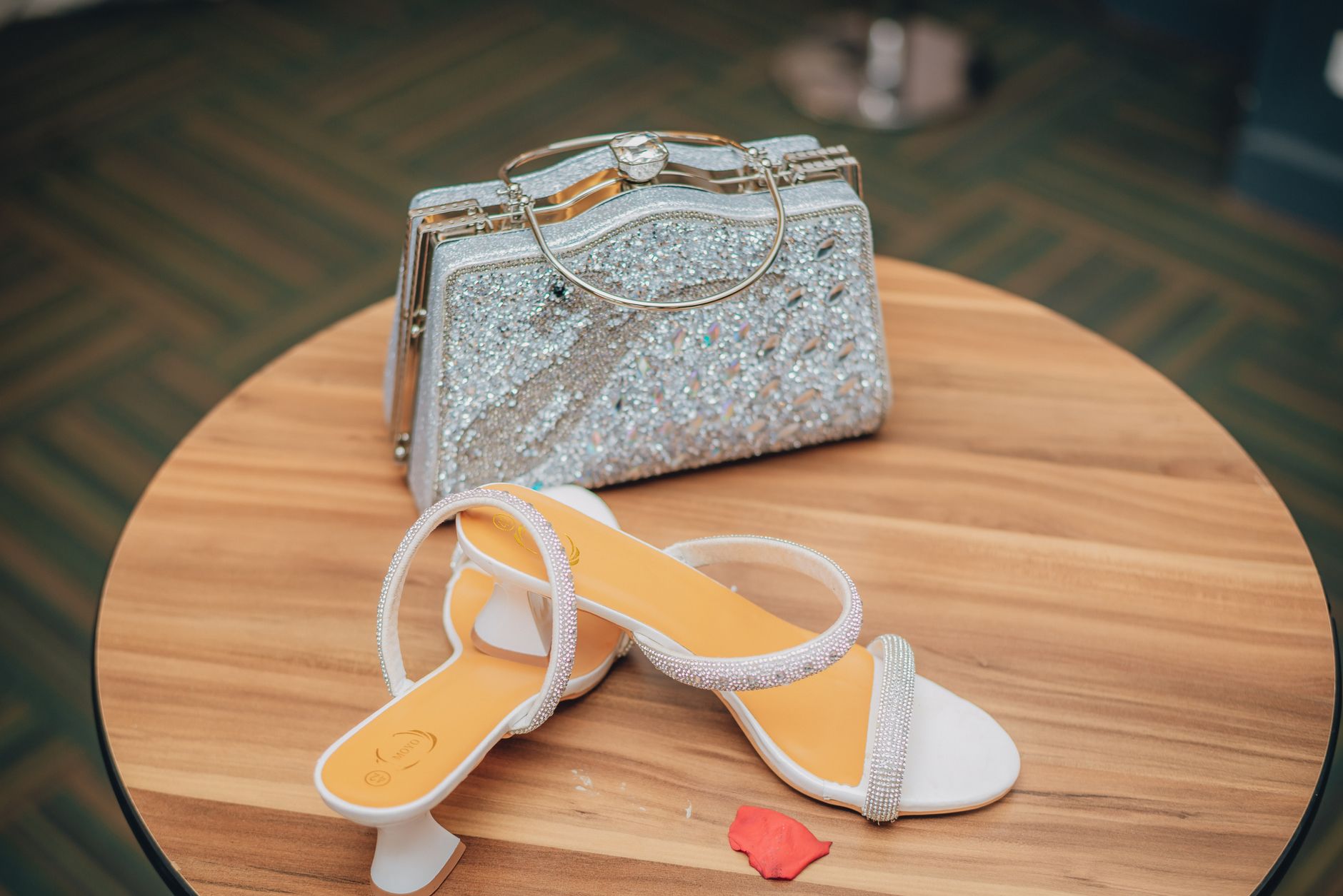 Luxury designer handbag and heels arranged on a neutral background