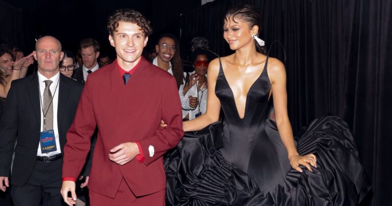 Couple walking a Hollywood red carpet premiere at night