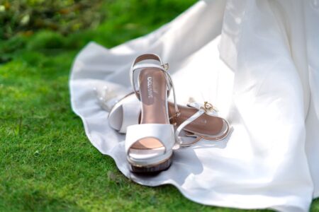 Close-up of a satin wedge heel shoe with embroidered detailing on the upper