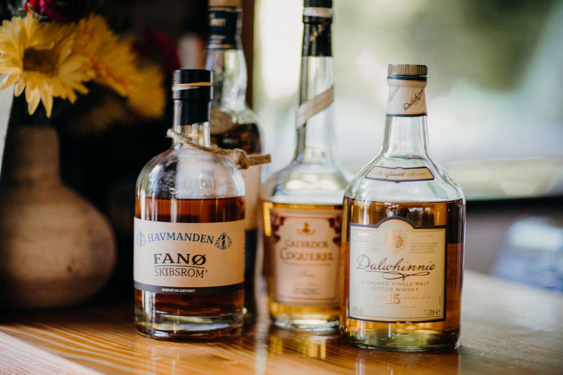 A glass of amber whisky resting on a dark wooden table, evoking luxury and patience