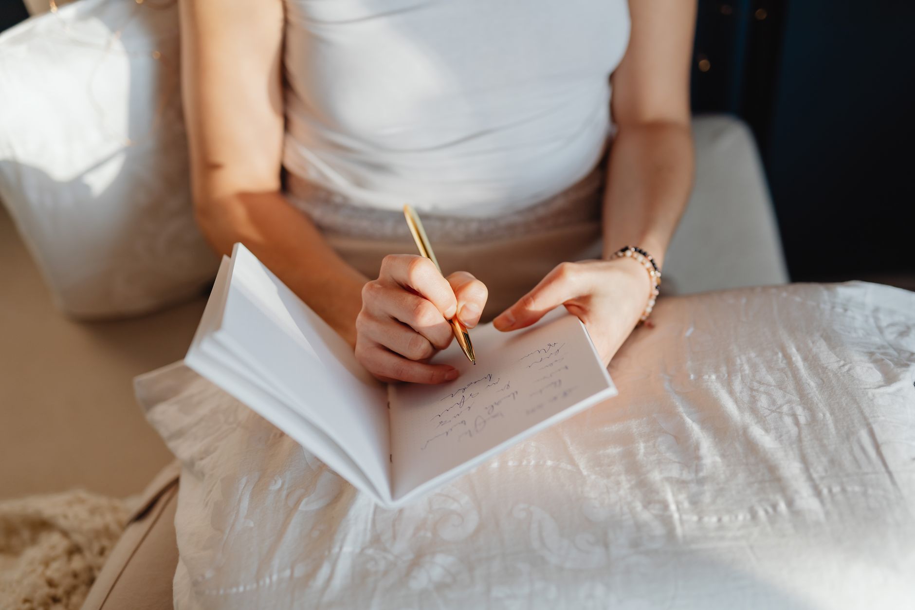 Woman writing in journal by window, reflecting on emotions and personal decisions