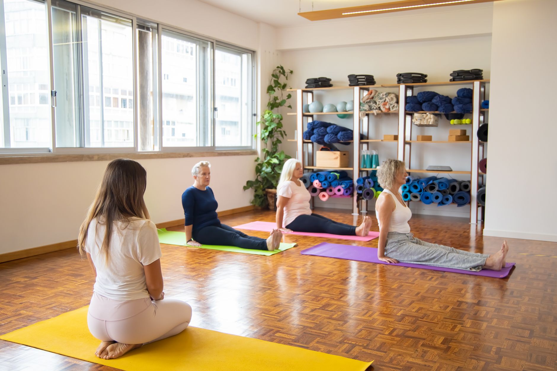A yoga instructor leading a class, echoing the character of Kai played by Adam Demos in Spa Weekend