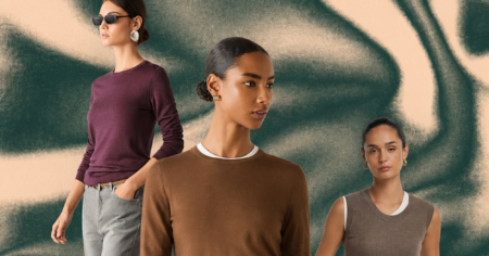 Folded luxury cashmere sweaters in neutral tones stacked on a wooden surface