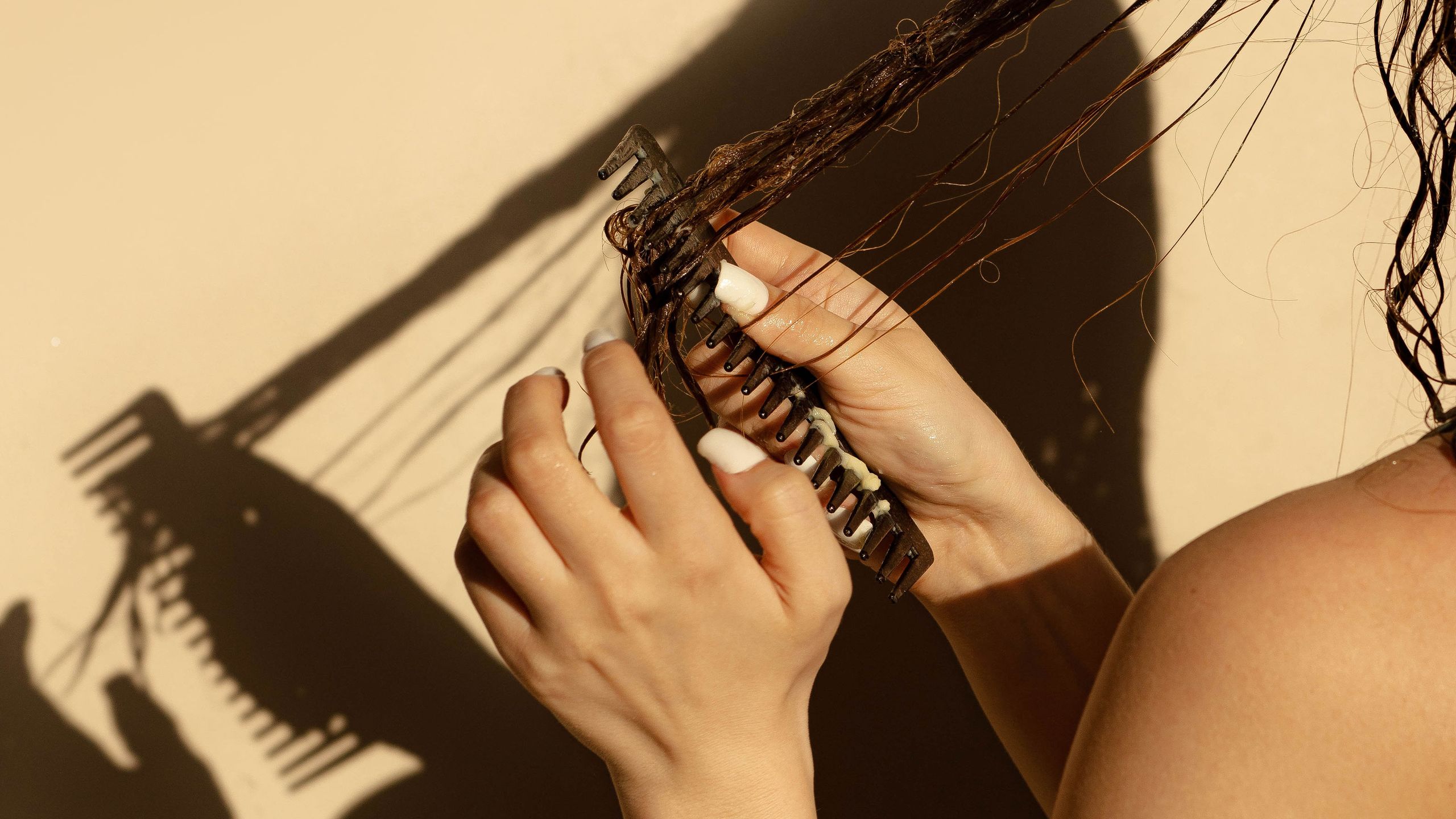 Woman examining her hair in a mirror, reflecting concerns about hair shedding