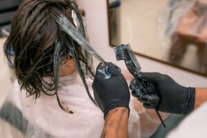 Stylist applying hair color treatment in a professional salon setting