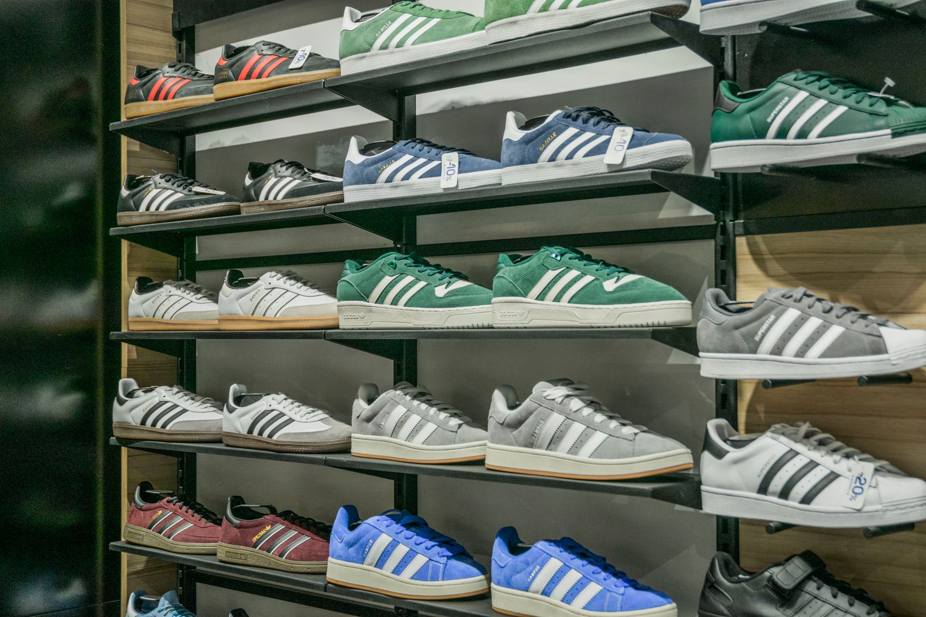 Row of athletic sneakers displayed on shelves inside a modern sportswear retail store