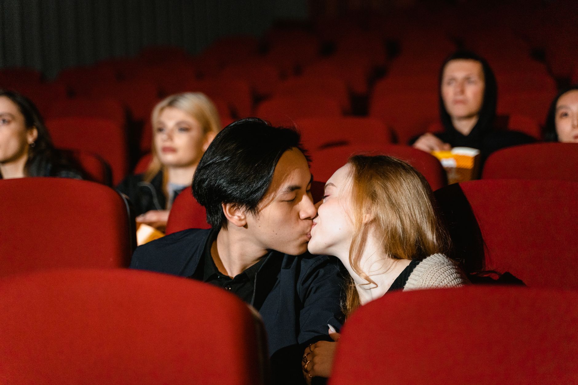 Couple watching a film together in a dimly lit setting