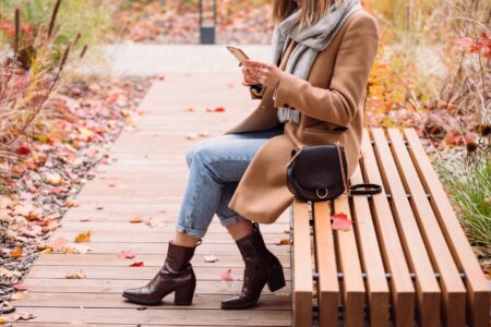 Steve Madden, Marc Jacobs, and Vivaia Own Fall Boot Season Model wearing tall leather boots with a winter outfit in an urban setting