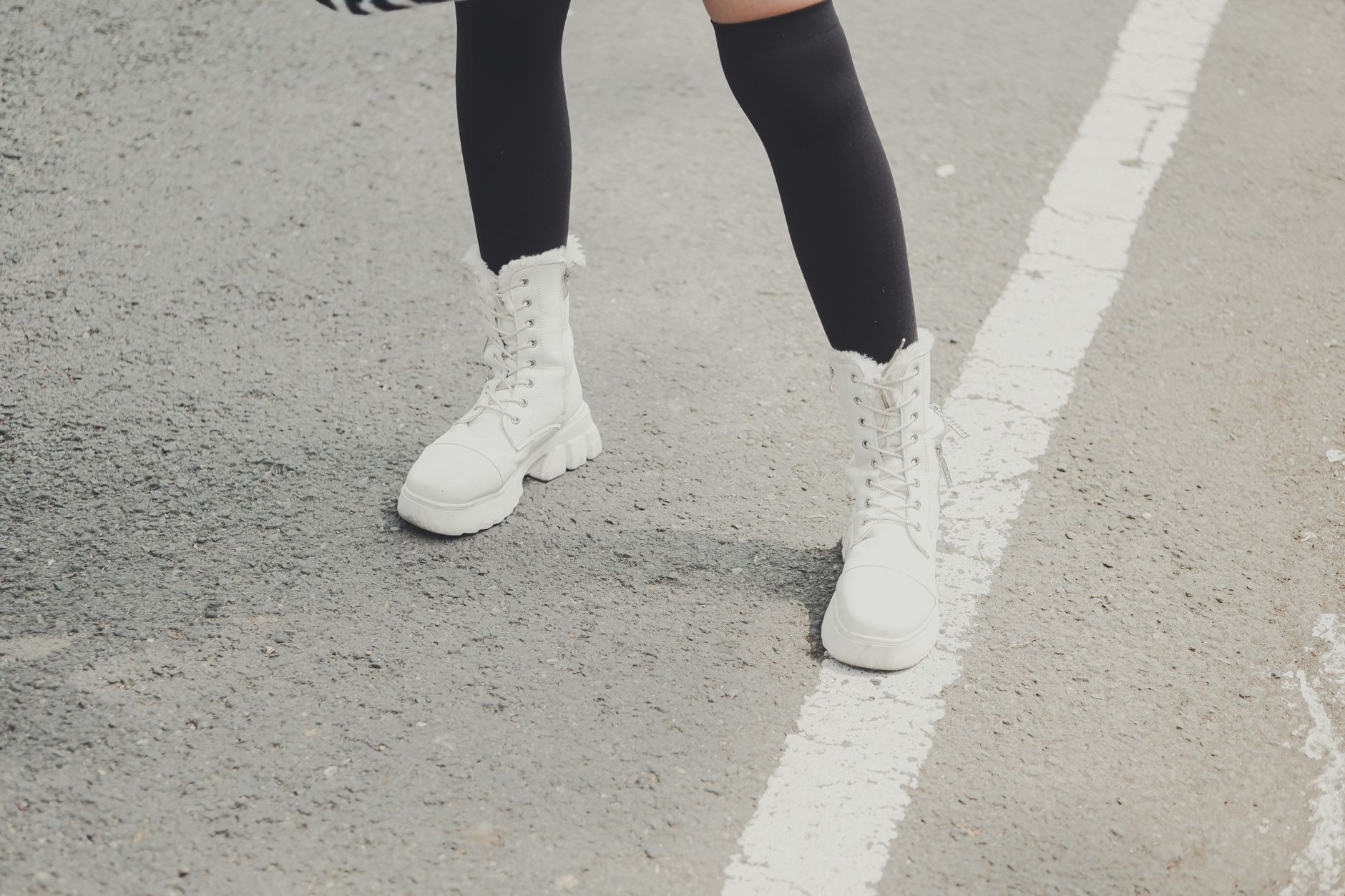 Close-up of knee-high suede boots styled with straight-leg jeans